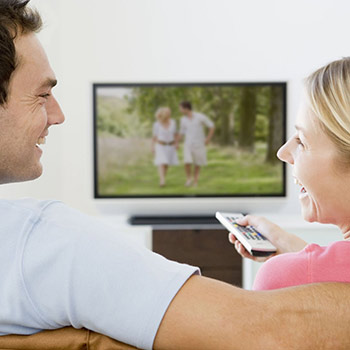 Paar lacht vor dem Fernseher