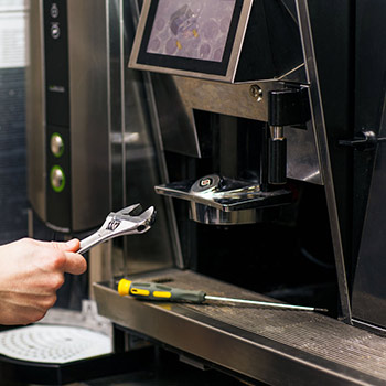 Zange an einem Kaffeevollautomaten