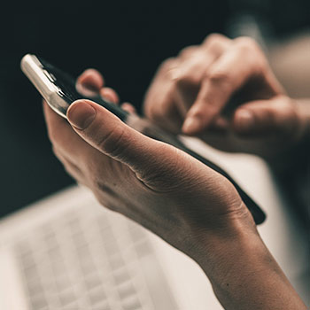 Hand, die etwas auf dem Smartphone tippt