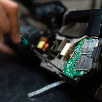 Eine Hand die eine Steuermodul repariert